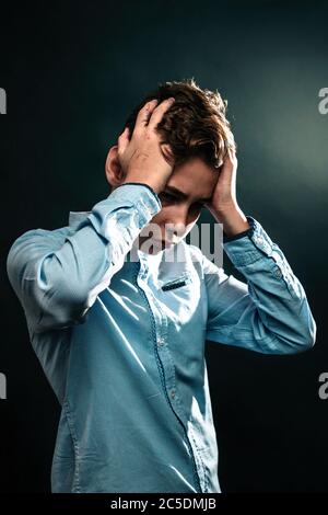 Das Konzept der häuslichen Gewalt. Ein Teenager hält seine Hände über den Kopf und erlebt Stress. Vertikal. Stockfoto
