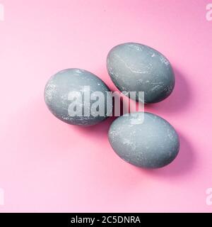 Drei graue Ostereier auf rosa Hintergrund. Draufsicht, flach liegend. Speicherplatz kopieren. Frohe Ostern Konzept Stockfoto
