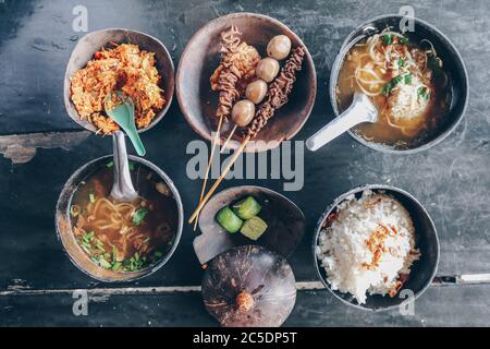 Soto Batok. Javanische Rindfleisch klare Suppe mit Bohnensprossen und Reis; serviert in einer traditionellen Schüssel aus Kokosnuss Schale, lokal bekannt als ‘Batok’. Accompa Stockfoto