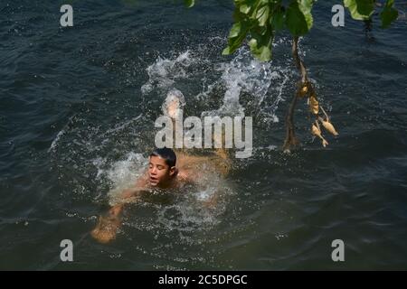 Srinagar, Indien. Juli 2020. Ein Kashmiri Junge kühlt sich in einem Strom, um die Hitze am heißen Sommertag in Srinagar zu schlagen.während Kashmir im Griff der heißen und feuchten Wetterbedingungen mit seiner Temperatur blieb hoch, erlebte Srinagar Stadt den heißesten Tag dieses Sommers mit Quecksilber berühren 33 Grad Celsius. (Foto von Musaib Mushtaq/Pacific Press) Quelle: Pacific Press Agency/Alamy Live News Stockfoto