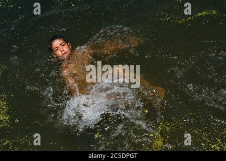 Srinagar, Indien. Juli 2020. Ein Kashmiri Junge kühlt sich in einem Strom, um die Hitze am heißen Sommertag in Srinagar zu schlagen.während Kashmir im Griff der heißen und feuchten Wetterbedingungen mit seiner Temperatur blieb hoch, erlebte Srinagar Stadt den heißesten Tag dieses Sommers mit Quecksilber berühren 33 Grad Celsius. (Foto von Musaib Mushtaq/Pacific Press) Quelle: Pacific Press Agency/Alamy Live News Stockfoto