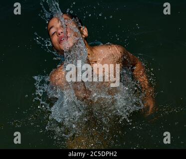 Srinagar, Indien. Juli 2020. Ein Kashmiri Junge kühlt sich in Dal Lake, um die Hitze am heißen Sommertag in Srinagar zu schlagen.mit Kaschmir blieb im Griff von heißen und feuchten Wetterbedingungen mit seiner Temperatur hoch, Srinagar Stadt Zeuge der heißesten Tag dieses Sommers mit Quecksilber berühren 33 Grad Celsius. (Foto von Musaib Mushtaq/Pacific Press) Quelle: Pacific Press Agency/Alamy Live News Stockfoto