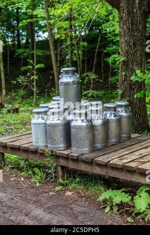 Bellville, PA, USA - 23. Mai 2013: Milchdosen auf einer Ladeplattform, die von einer Amish Farm im Kishacoquillas Valley im Mifflin County, PA, abgeholt werden können Stockfoto