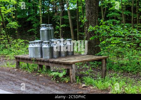 Bellville, PA, USA - 23. Mai 2013: Milchdosen auf einer Ladeplattform, die von einer Amish Farm im Kishacoquillas Valley im Mifflin County, PA, abgeholt werden können Stockfoto