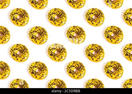 Flaches Muster aus Donuts auf weißem Hintergrund mit gelber Glasur und Schokolade. Der Blick von oben. Minimalkonzept ungesunde Lebensmittel Stockfoto