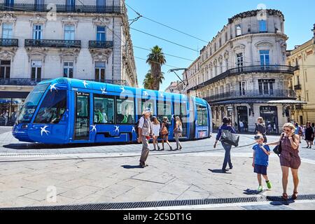 MONTPELLIER, FRANKREICH - 24. Juni 2015: Architektur des Place de la Comedie. Fußgänger und blaue Straßenbahn. Öffentliche Verkehrsmittel in der Stadt auf der Straße Stockfoto