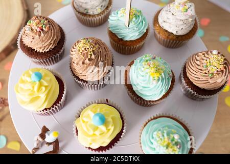 Bunte hausgemachte Cupcakes auf einem weißen Teller serviert Nahaufnahme noch Stockfoto