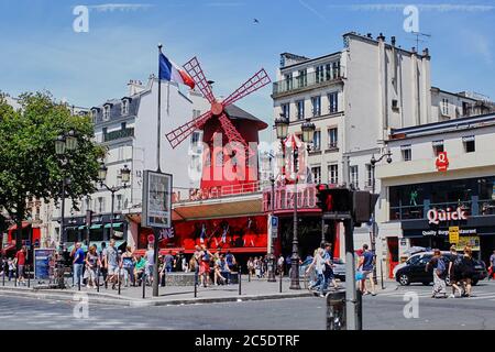 Paris, Frankreich - 28. Juni 2015: Moulin Rouge ist ein berühmtes Kabarett in der Stadt. Das Rotlichtviertel Pigalle. Menschen, die den Bürgersteig entlang gehen. Summe Stockfoto