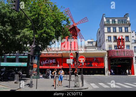 Paris, Frankreich - 28. Juni 2015: Moulin Rouge ist ein berühmtes Kabarett in der Stadt. Das Rotlichtviertel Pigalle. Menschen, die den Bürgersteig entlang gehen. Summe Stockfoto
