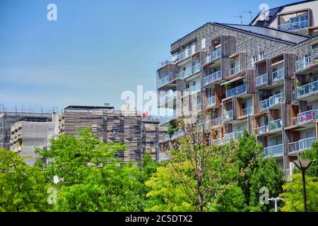 Paris, Frankreich - 28. Juni 2015: Eco-Quartier Clichy-Batignolles. Neue Moderne Architektur. Park Martin Luther King. Grüne Baumkronen und Baufakade Stockfoto