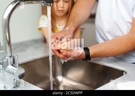 Vater und Tochter waschen sich die Hände über dem Waschbecken in einer Küche Stockfoto