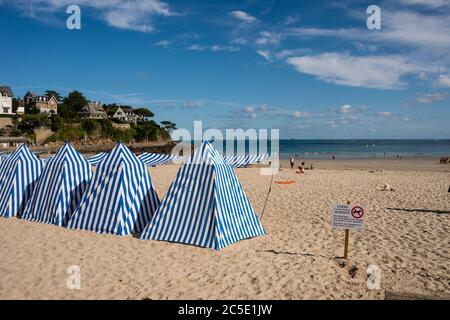 Blau und weiß gestreifte Sonnenschirme am Strand Plage de L'Ecluse, Dinard, Bretagne, Frankreich Stockfoto