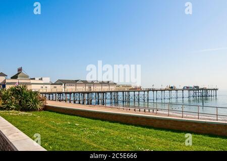 Teignmouth Grand Pier reicht über ein blaues Meer zum Horizont mit gusseisernen Säulen, die stilvolle Pavillons und Attraktionen unterstützen Stockfoto