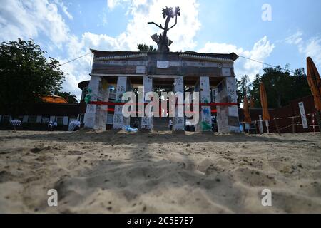 Berlin, Deutschland. Juli 2020. Vor der Einweihung wird ein rotes Band um das Müllburger Tor im lido Plötzensee gewickelt. Die 5 Meter breite und 2 Meter hohe Anlage in Form des Brandenburger Tors aus Pizzabästen, To-Go-Bechern, Plastikflaschen und anderen Verpackungsabfällen soll zur Abfallvermeidung beitragen. Quelle: Sven Braun/dpa/Alamy Live News Stockfoto
