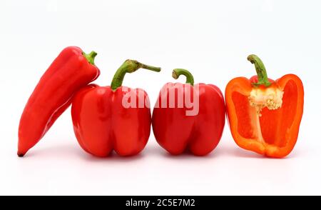 Wenige rote reife Paprika und ein Pfeffer in einem Schnitt auf hellem Hintergrund. Naturprodukt. Natürliche Farbe. Nahaufnahme. Stockfoto