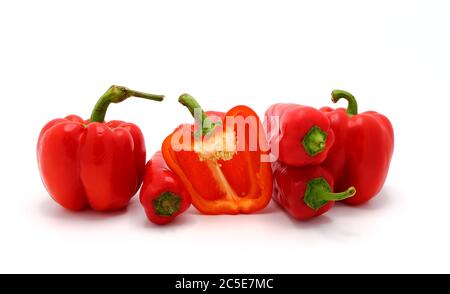 Wenige rote reife Paprika und ein Pfeffer in einem Schnitt auf hellem Hintergrund. Naturprodukt. Natürliche Farbe. Nahaufnahme. Stockfoto