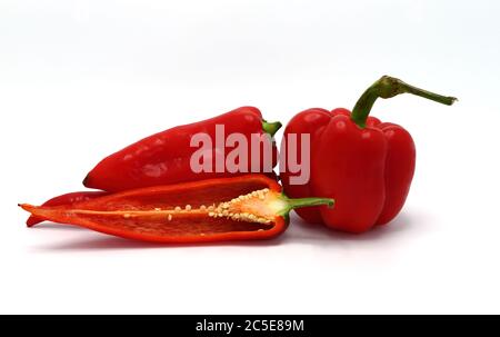 Wenige rote reife Paprika und ein Pfeffer in einem Schnitt auf hellem Hintergrund. Naturprodukt. Natürliche Farbe. Nahaufnahme. Stockfoto