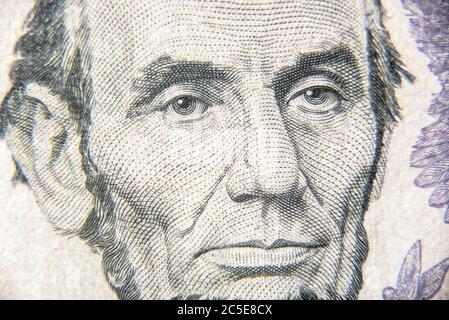 Abraham Abe Lincoln Gesicht auf 5 Dollar-Schein Nahaufnahme. Porträt des berühmten US-Präsidenten auf Dollar-Banknote. Makroansicht des US-Papiergeldes. Detail der neuen c Stockfoto