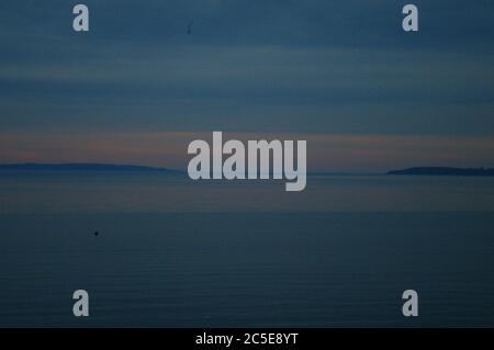 Dunstig Sonnenuntergang Traverse City Bay, Dämmerung in Traverse City Bay, Rosa Sonnenuntergang in der Dämmerung, Rosa Sonnenuntergang in der Dämmerung über der Bucht, Pink Sunset Sandstrand, Sandstrand Stockfoto