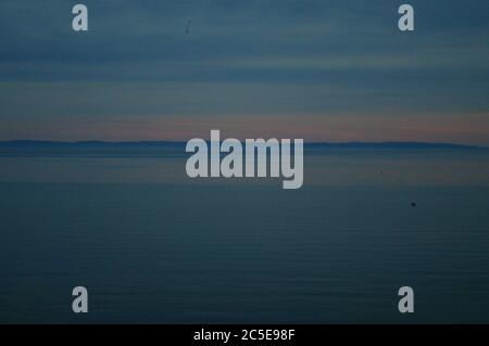 Dunstig Sonnenuntergang Traverse City Bay, Dämmerung in Traverse City Bay, Rosa Sonnenuntergang in der Dämmerung, Rosa Sonnenuntergang in der Dämmerung über der Bucht, Pink Sunset Sandstrand, Sandstrand Stockfoto