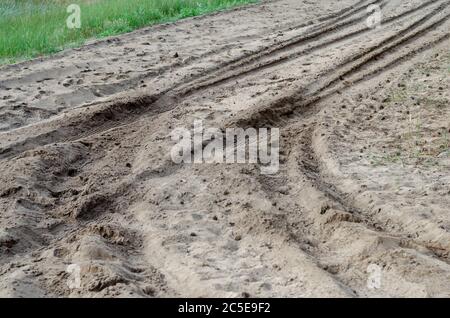 Spuren des Autos im Sand. Abdrücke von Reifenspuren eines SUV auf einer sandigen Straße. Reisen, Tourismus und Freizeit. Selektiver Fokus. Stockfoto