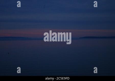 Dunstig Sonnenuntergang Traverse City Bay, Dämmerung in Traverse City Bay, Rosa Sonnenuntergang in der Dämmerung, Rosa Sonnenuntergang in der Dämmerung über der Bucht, Pink Sunset Sandstrand, Sandstrand Stockfoto