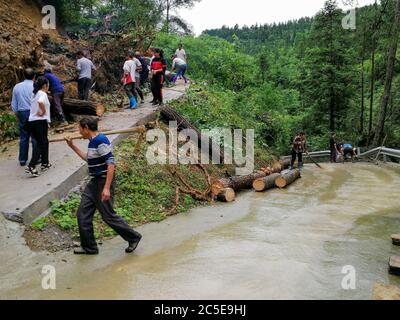 Chongqing, China. Juli 2020. Lokale Beamte und Bewohner räumen nach sintflutartigen Regenfällen im Bezirk Qianjiang der Gemeinde Chongqing, Südwestchina, 2. Juli 2020 eine Straße ab. Schwere Regengüsse haben Teile der Stadt von Mittwoch Morgen bis Donnerstag Morgen geschlagen. Quelle: Jian Xingze/Xinhua/Alamy Live News Stockfoto