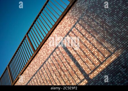 Geländer und U-Bahn-Wand mit klarem blauen Himmel Stockfoto