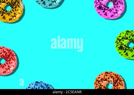 Donuts sind auf einem hellen Hintergrund mit einer Kopie des Raumes gefärbt. Ungesunde Ernährung. Minimaler Sommer-Template Stockfoto