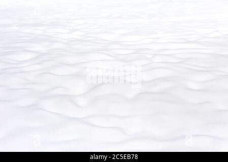 Hintergrund der Schnee Textur. Schlichte, schneebedeckte Landschaft. Szene der weißen Oberfläche im Winter. Heller Neuschnee Nahaufnahme. Natürliches, glattes Muster für Abstraktion Stockfoto