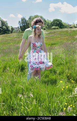 Junge Liebhaber, die Spaß an einem sonnigen Sommertag auf einer Wiese in einem London Park, Springfield Park, London, Model Release verfügbar Stockfoto