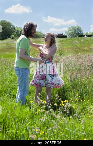 Junge Liebhaber, die Spaß an einem sonnigen Sommertag auf einer Wiese in einem London Park, Springfield Park, London, Model Release verfügbar Stockfoto