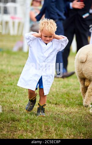 Ein kleiner Junge reagiert während einer Aufführung der RAF Halton Pipes and Drums auf der Bucks County Show 2019 im Weedon Park bei Aylesbury Stockfoto