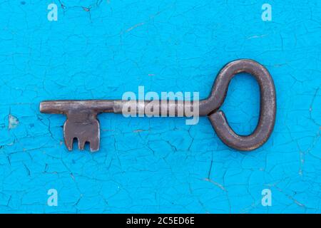 Alte Eisenschlüssel isoliert auf blauem Hintergrund Stockfoto