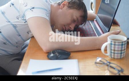 Müde von harten Arbeit Student Kerl schlafen auf Laptop am Tisch Stockfoto