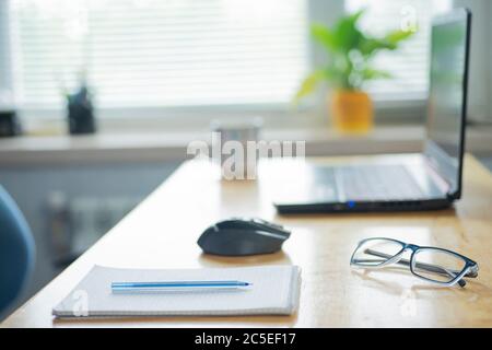 Ein Notizbuch mit der Aufschrift Arbeit liegt auf dem Tisch. Daneben liegt ein Stift und eine Brille. Konzept der Arbeit Stockfoto