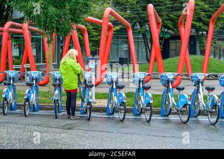 Frau in Shaw, mobi Fahrradverleihstation, Main Street, Vancouver, British Columbia, Kanada Stockfoto