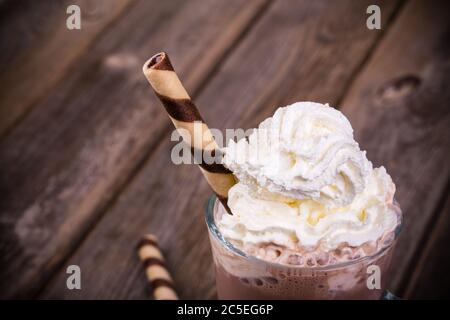 Heiße Schokolade mit Schlagsahne Belag, im Glas mit gerollten Wafer. Verarbeitung mit Vintage-Effekt Stockfoto