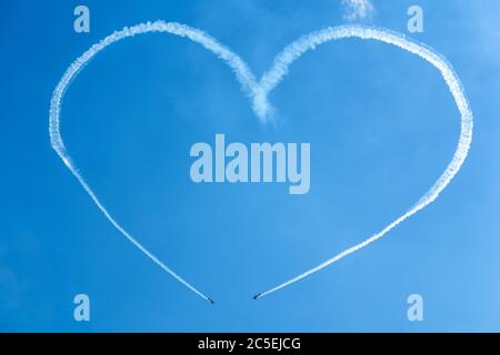 Ein Herz am blauen Himmel von zwei skywriting kleinen Flugzeugen bei einer Flugshow Stockfoto