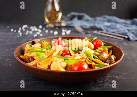 Feigwaren mit Gemüse, Blumenkohl und Pilzen unter Rühren braten Stockfoto