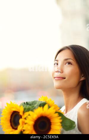 Blume Frau hält Sonnenblume lächelnd glücklich Stockfoto