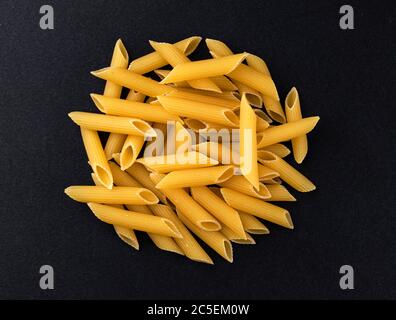 Rohe Penne Rigate Pasta isoliert auf schwarzem Hintergrund, Draufsicht Stockfoto