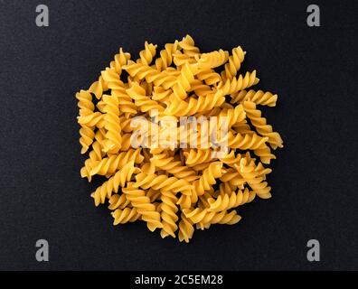 Rohe Fusilli Pasta isoliert auf schwarzem Hintergrund, Draufsicht Stockfoto