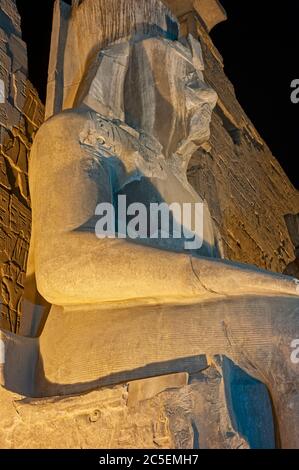 Große Statue von Ramses II am Eingangspylon zum alten ägyptischen Luxor Tempel beleuchtet während der Nacht Stockfoto
