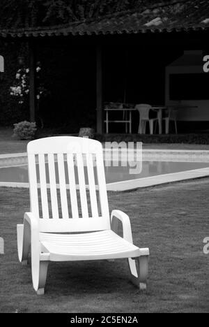 PVC Liegestuhl auf Rasen mit Pool und Grill im Hintergrund, Itaipava, Rio de Janeiro, Brasilien Stockfoto