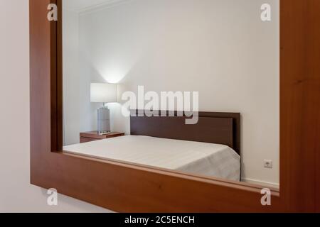 Modernes, stilvolles Schlafzimmer im Haus, Hotel, im Spiegel reflektiert. Konzeptfoto. Stockfoto