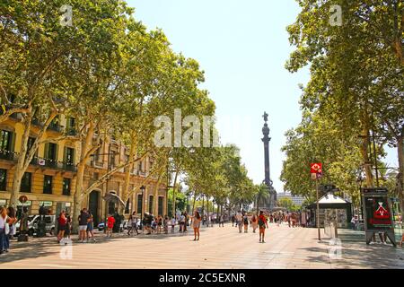 Blick auf die Rambla in Richtung des Christopher Columbus-Denkmals in Port Vell. Es ist eine Fußgängerzone mit Bäumen gesäumten Straße im Zentrum von Barcelona, Katalonien, Spanien. Stockfoto