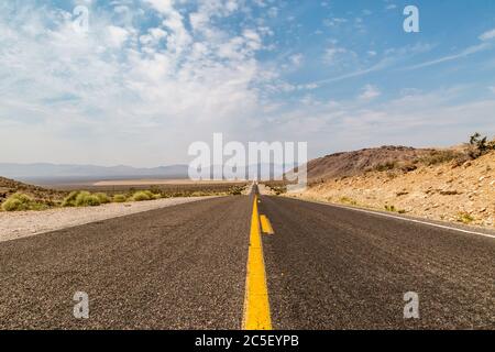 Blick auf die lange gerade Straße, die zum Death Valley führt Stockfoto