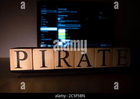 Piratenworte auf Holzwürfeln auf Laptop. Stockfoto