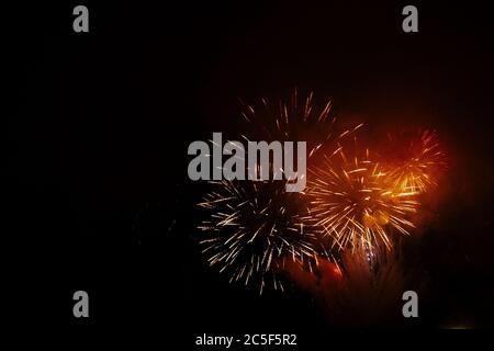 Farbige nächtliche Explosionen in schwarzem Himmel. Feuerwerk zu Ehren von Weihnachten oder am 5. November, 4. Juli auf schwarzem Hintergrund. Stockfoto
